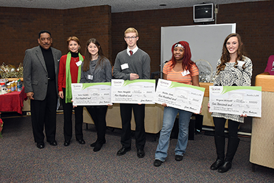 Genisys CEO, Jackie Buchanan and Tom Kimble pose with Four Students presenting scholarships
